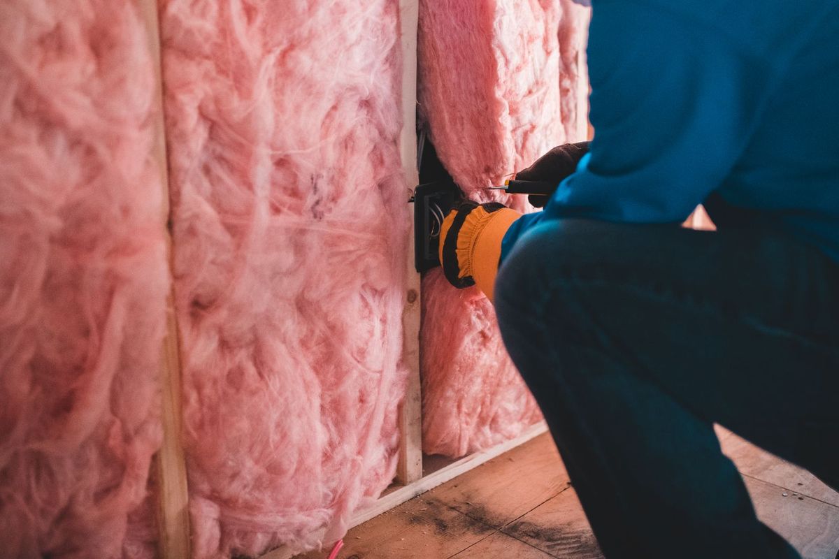 Fiberglass batt insulation being installed in a wall